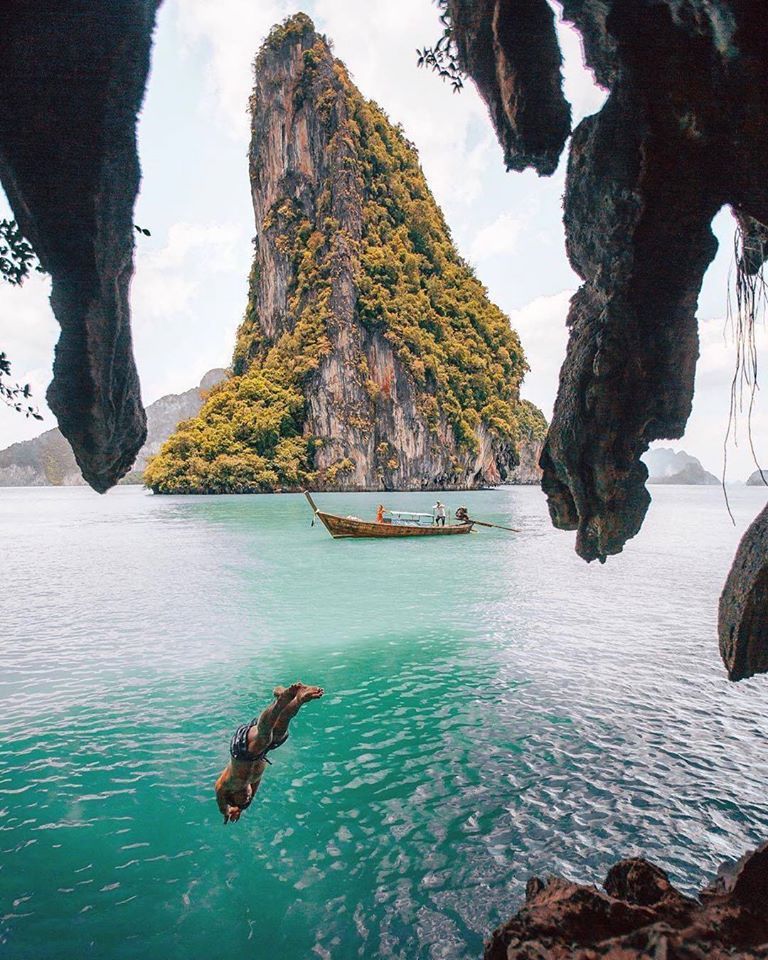 Phuket yacht charter — limestone cliff and longtail in Phang Nga Bay